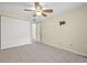 Bedroom showcasing tile floors, a double closet, and a ceiling fan at 8405 Woodbridge Blvd, Tampa, FL 33615