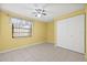 Bedroom with yellow walls, tile flooring, a closet, and a window at 8405 Woodbridge Blvd, Tampa, FL 33615