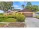 Charming single-story home featuring a two-car garage and lush landscaping for added curb appeal at 8405 Woodbridge Blvd, Tampa, FL 33615