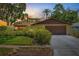 Charming single-story home at sunset featuring a two-car garage and lush landscaping for added curb appeal at 8405 Woodbridge Blvd, Tampa, FL 33615