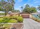 Charming single-story home featuring a two-car garage and lush landscaping for added curb appeal at 8405 Woodbridge Blvd, Tampa, FL 33615