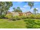Well-maintained lawn and mature trees complement this lovely home, enhancing its curb appeal at 8405 Woodbridge Blvd, Tampa, FL 33615