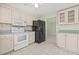 Traditional kitchen featuring white cabinets, a black refrigerator, and light tile flooring at 8405 Woodbridge Blvd, Tampa, FL 33615