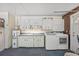 Laundry room includes a washer, dryer, cabinets, and utility sink at 8405 Woodbridge Blvd, Tampa, FL 33615