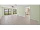 Spacious living room with tile floors, ceiling fan, and natural light from large windows at 8405 Woodbridge Blvd, Tampa, FL 33615