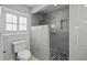 Updated bathroom highlighting a glass enclosed shower with gray tile and black and white mosaic flooring at 8718 Tahiti Ln, Tampa, FL 33615