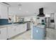 Bright kitchen with granite countertops, island cooktop, stainless steel appliances, and blue backsplash at 8718 Tahiti Ln, Tampa, FL 33615