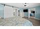 Comfortable main bedroom with ceiling fan, sliding barn door, and ensuite bathroom at 8718 Tahiti Ln, Tampa, FL 33615