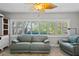Bright sunroom with large windows, plantation shutters, ceiling fan, and comfortable seating at 8718 Tahiti Ln, Tampa, FL 33615