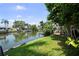 Green lawn meeting a serene waterway, complemented by lush trees and private boat docks at 8718 Tahiti Ln, Tampa, FL 33615