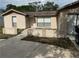 Tan single story home featuring a driveway and a concrete walkway to the front door at 8801 Orange Blossom Dr, Seminole, FL 33772
