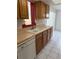 Kitchen with white dishwasher and sink under wood cabinets with marble countertops at 8801 Orange Blossom Dr, Seminole, FL 33772