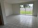 Spacious living room with white tile flooring and sliding glass doors to the backyard at 8801 Orange Blossom Dr, Seminole, FL 33772