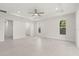 Spacious bedroom with a ceiling fan, light tile flooring, and natural light from two windows at 9073 Fruitland Ave, Englewood, FL 34224