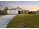 Beautifully landscaped front yard leading to a charming single-story home with a two car garage at 9073 Fruitland Ave, Englewood, FL 34224