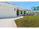 Side view of a home with a two-car garage, manicured lawn and inviting front entrance at 9073 Fruitland Ave, Englewood, FL 34224