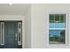 Close-up of the home's entrance featuring a front door with sidelights and white trim at 9073 Fruitland Ave, Englewood, FL 34224