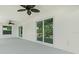 A covered patio with sliding glass doors, ceiling fans and gray painted floor at 9073 Fruitland Ave, Englewood, FL 34224