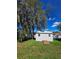 Exterior view of the backyard shed with a wooden ramp, green grass, and blue sky at 9171 Vicksburg Rd, Spring Hill, FL 34608
