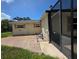 Rear exterior view of a single-story home with a screened pool and lawn at 9171 Vicksburg Rd, Spring Hill, FL 34608