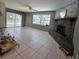 Cozy living room with a stone fireplace and view of the patio at 9171 Vicksburg Rd, Spring Hill, FL 34608