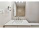 Bathroom with an updated sink, faucet, and a large mirror over the vanity and toilet at 9312 N Tampa St, Tampa, FL 33612