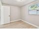 Bright bedroom features a window and light wood-look flooring, complementing the fresh paint at 9312 N Tampa St, Tampa, FL 33612