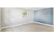 Light-filled bedroom showcasing wood-look floors, white walls, and a blue accent wall, with a window view at 9312 N Tampa St, Tampa, FL 33612