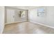 Bright bedroom featuring wood-look flooring, light grey walls, and natural light from two windows at 9312 N Tampa St, Tampa, FL 33612