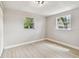 Bright bedroom with two windows, wood-look flooring, and neutral color scheme at 9312 N Tampa St, Tampa, FL 33612