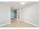 Spacious bedroom featuring white walls, wood-look flooring, and views of the home's open layout at 9312 N Tampa St, Tampa, FL 33612