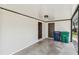 Carport featuring concrete flooring, white brick walls, and lighting fixture at 9312 N Tampa St, Tampa, FL 33612