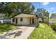 This single-story home features a carport, fresh exterior paint, a well-kept lawn, and a long driveway at 9312 N Tampa St, Tampa, FL 33612