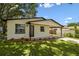 Inviting home featuring a carport, well-maintained lawn, and fresh exterior paint at 9312 N Tampa St, Tampa, FL 33612
