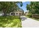 This attractive single-story home has a long driveway, carport, and a well-maintained front lawn at 9312 N Tampa St, Tampa, FL 33612