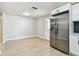 Bright kitchen with stainless steel refrigerator, white cabinets, a stylish backsplash, and wood-look flooring at 9312 N Tampa St, Tampa, FL 33612