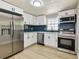 Updated kitchen featuring stainless steel appliances, white cabinets, stylish backsplash, and modern lighting at 9312 N Tampa St, Tampa, FL 33612