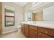 Bright bathroom features a wooden vanity, neutral tile floor, and natural light from a window at 9807 Stephenson Dr, New Port Richey, FL 34655
