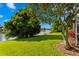 Picturesque backyard view overlooking a tranquil lake, lush lawn, and mature trees at 10361 Lightner Bridge Dr, Tampa, FL 33626