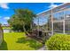 Well-manicured backyard featuring a screened lanai, lush landscaping, and serene waterfront views at 10361 Lightner Bridge Dr, Tampa, FL 33626
