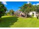 Expansive backyard with a screened-in lanai, lush lawn, and mature trees create a private oasis at 10361 Lightner Bridge Dr, Tampa, FL 33626