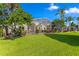 Spacious backyard with screened-in pool, mature trees, and lush green lawn for outdoor enjoyment at 10361 Lightner Bridge Dr, Tampa, FL 33626