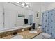 Bathroom boasts a double vanity with granite countertops, and decorative blue floral shower curtain at 10361 Lightner Bridge Dr, Tampa, FL 33626