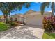 Inviting home featuring a two-car garage, vibrant landscaping and manicured lawn at 10361 Lightner Bridge Dr, Tampa, FL 33626