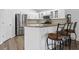 Kitchen featuring stainless steel appliances, granite countertops, bar seating, and white cabinets at 10361 Lightner Bridge Dr, Tampa, FL 33626