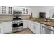 Kitchen area featuring stainless steel appliances, granite countertops, and white cabinets at 10361 Lightner Bridge Dr, Tampa, FL 33626