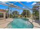 A pristine, enclosed pool under a bright sky, surrounded by lush landscaping and patio seating at 10361 Lightner Bridge Dr, Tampa, FL 33626