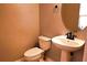 Well-lit half bathroom featuring a pedestal sink, updated fixtures, and neutral wall tones at 10819 Lake Saint Charles Blvd, Riverview, FL 33578