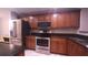 A kitchen with stainless steel appliances, dark counters, and wood cabinets at 10819 Lake Saint Charles Blvd, Riverview, FL 33578