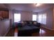 Cozy living room with hardwood floors, a sectional sofa, and large windows for natural light at 10819 Lake Saint Charles Blvd, Riverview, FL 33578